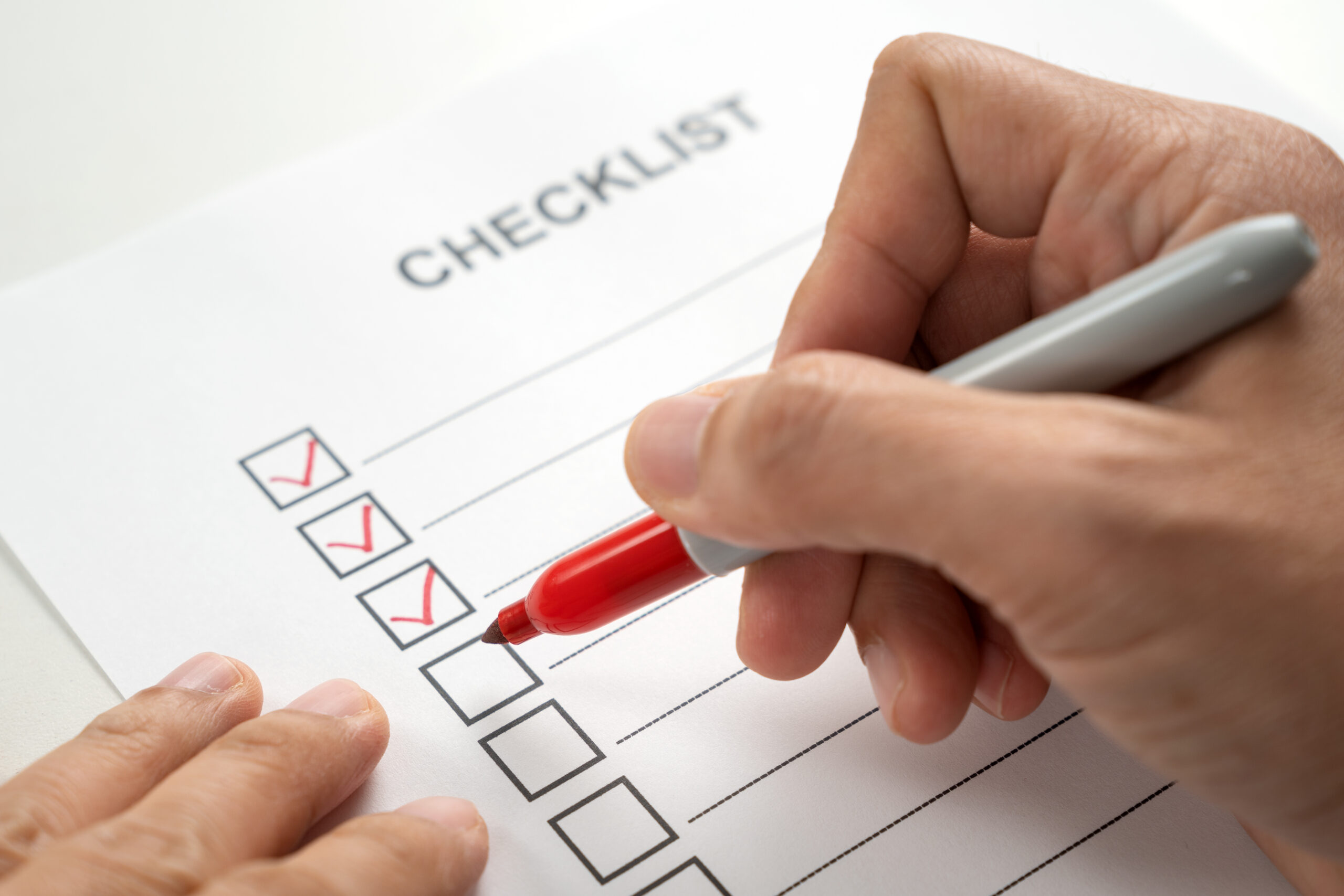 Checklist being marked with a red pen